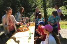 Die Kinder sitzen an einen Tisch und essen Brotscheiben