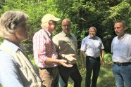 Ein Gruppe an Menschen stehen im Wald