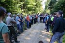 Eine Gruppe steht auf einem Waldweg im Kreis