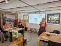 Person steht neben Leinwand und spricht
