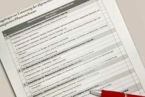 Checkliste mit einem Kugelschreiber liegt auf einem Tisch