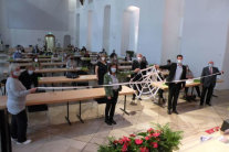Personen stehen in Raum und halten symbolisches Spinnennetz